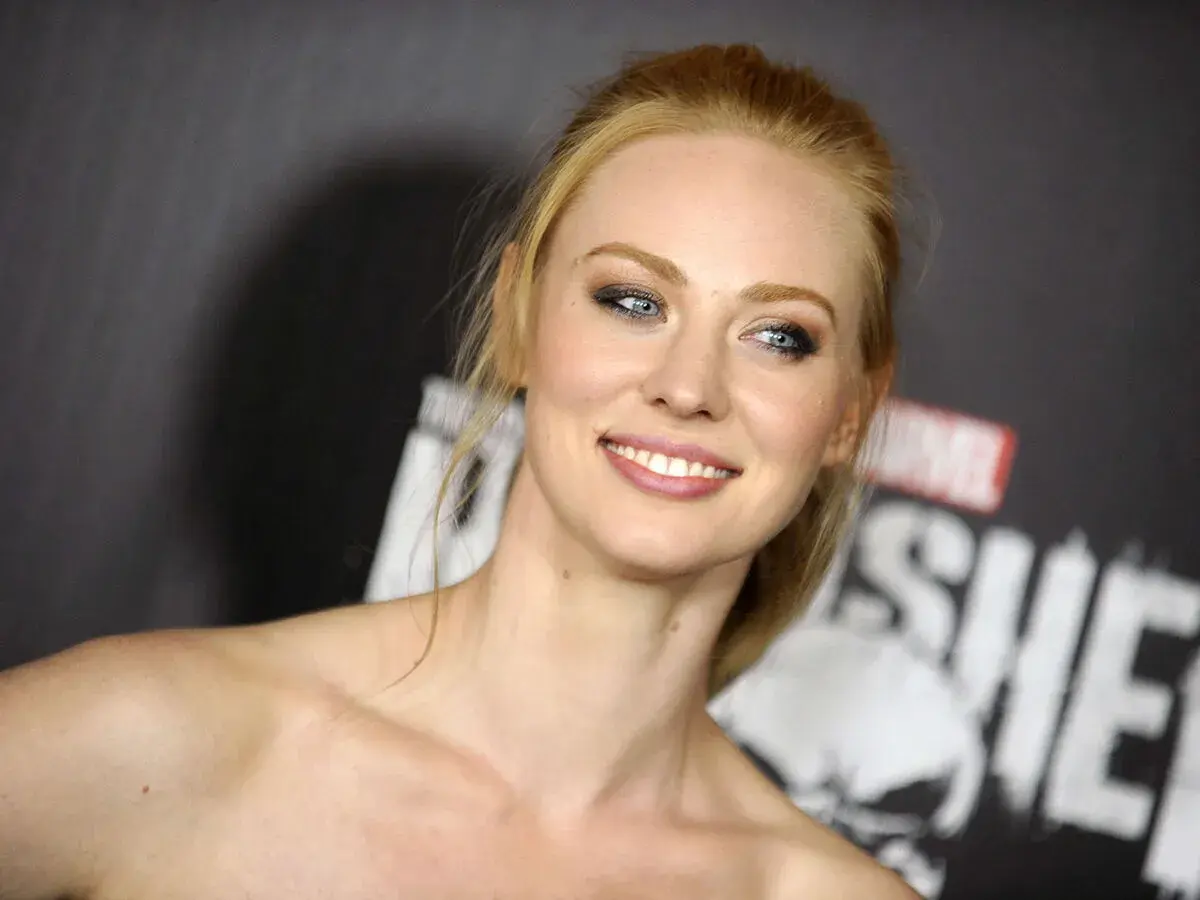 Deborah Ann Woll, qui a joué Karen Page, souriant devant le logo de The Punisher.