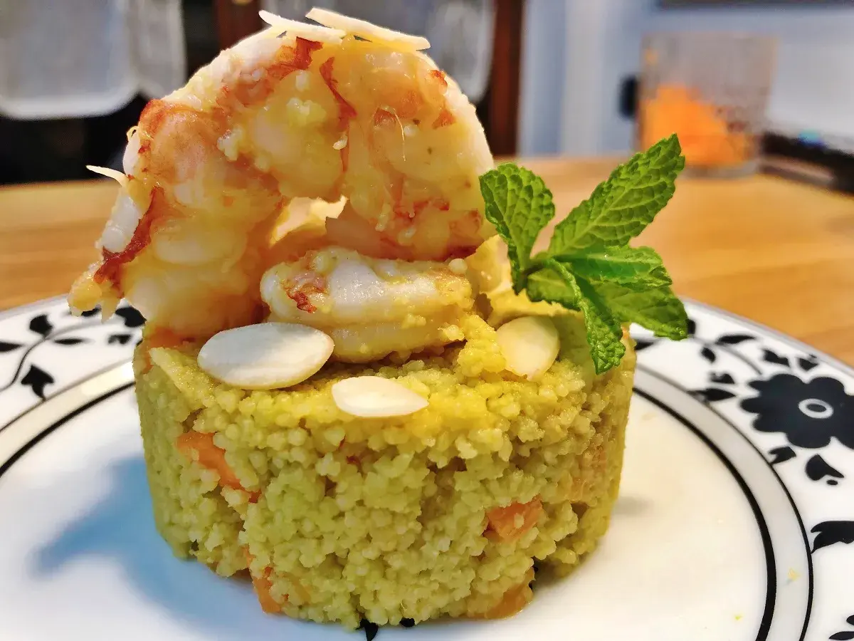 Un elegante cous cous gourmet con gamberi, mandorle e menta, un piatto raffinato.