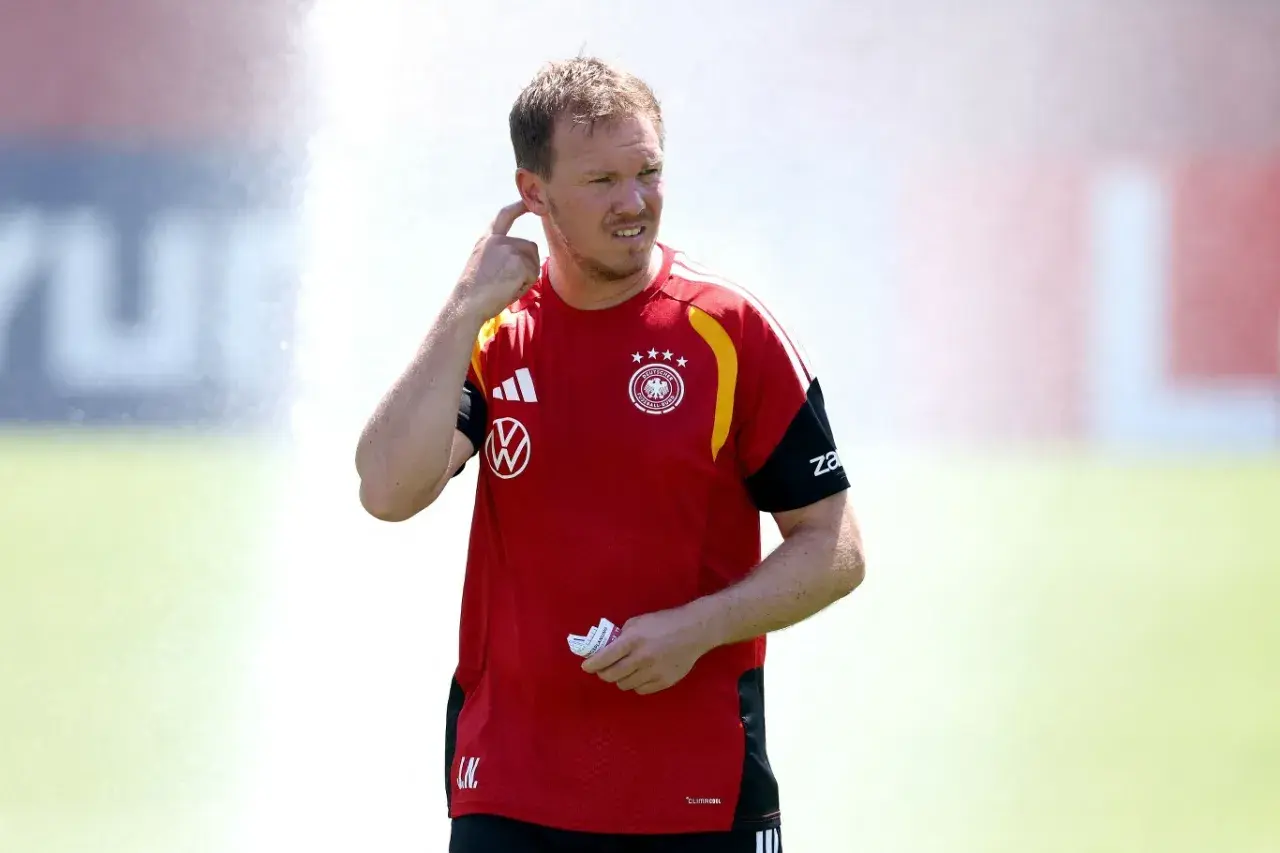Trener reprezentacji Niemiec, Julian Nagelsmann, w czerwonej koszulce z godłem DFB, gestykuluje podczas treningu.