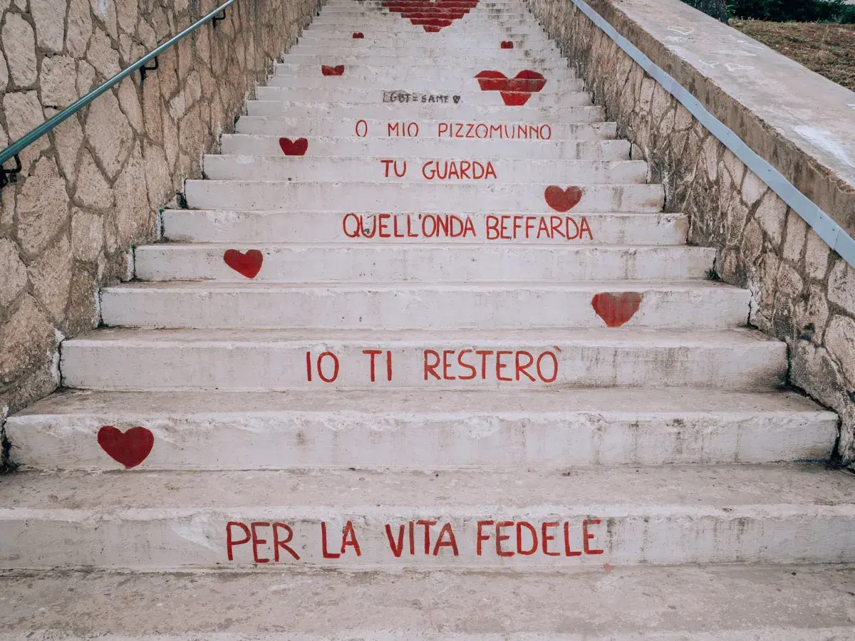 Scale a Vieste con cuori rossi e frasi d'amore dipinte. "O mio Pizzomunno, tu guarda quell'onda beffarda, io ti resterò per la vita fedele.