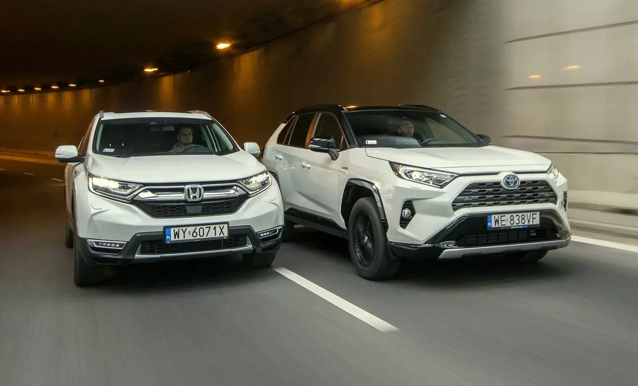 Dwa białe SUV-y, Honda CR-V i Toyota RAV4, jadą tunelem.