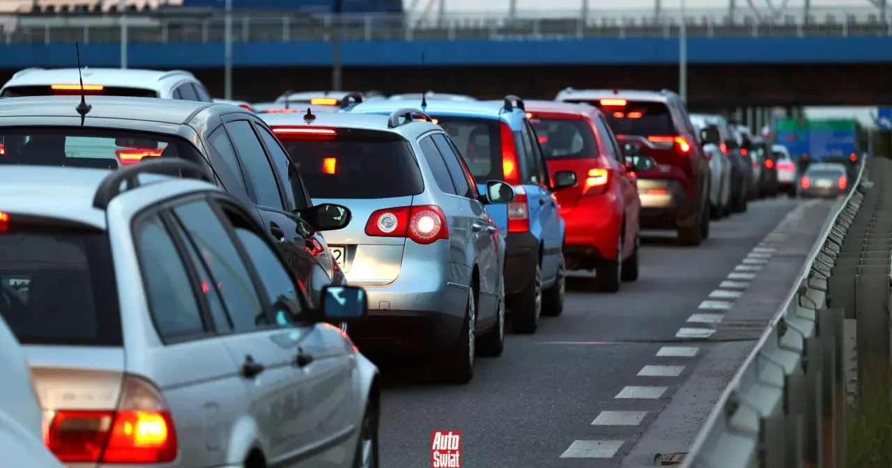 Korki na drogach w Polsce podczas wakacji. Długi sznur samochodów stoi na autostradzie, tworząc obraz typowych zakazów wakacyjnych.
