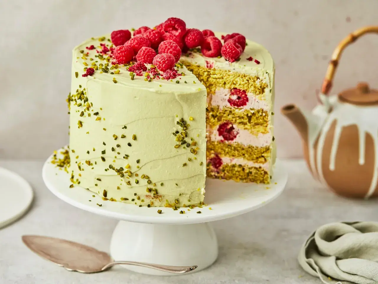 Ein köstlicher Pistazien Cheesecake mit frischen Himbeeren und gehackten Pistazien, bereit zum Servieren.