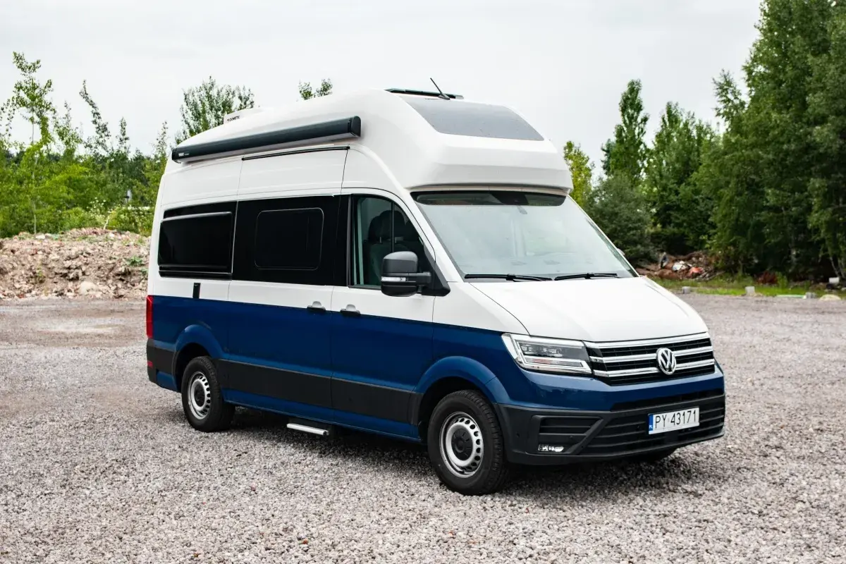 Nowoczesna produkcja kamperów: biało-niebieski Volkswagen Crafter z zabudową kempingową, gotowy na przygody.
