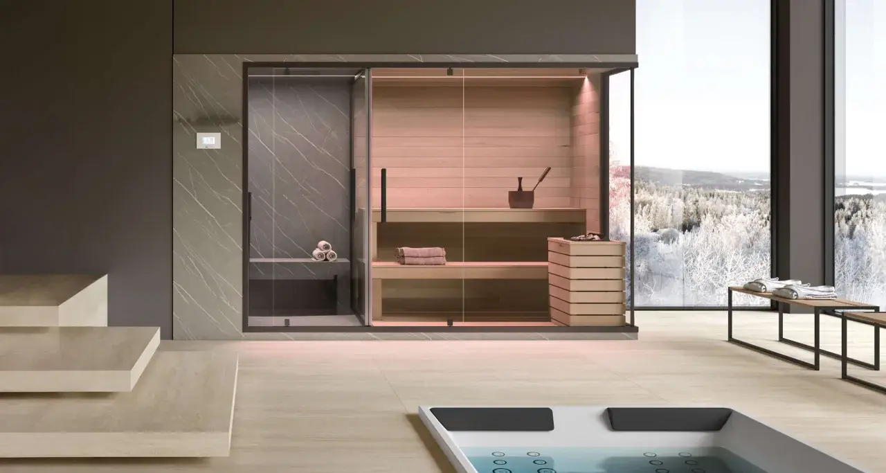 Un lussuoso mini spa in casa con sauna e doccia, affacciato su un paesaggio invernale innevato.