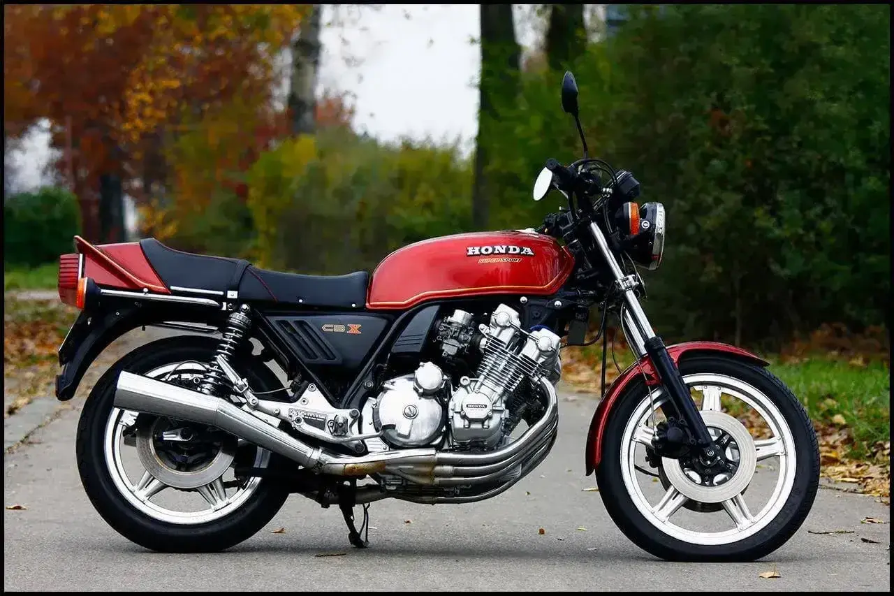 Czerwony motocykl Honda CBX 1000 z lat 80. na tle jesiennej przyrody.