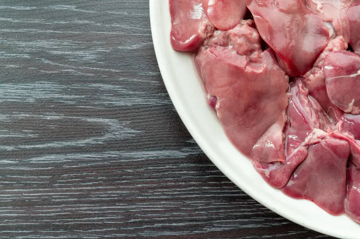 Piatto bianco con durelli di pollo crudi, pronti per essere cucinati.