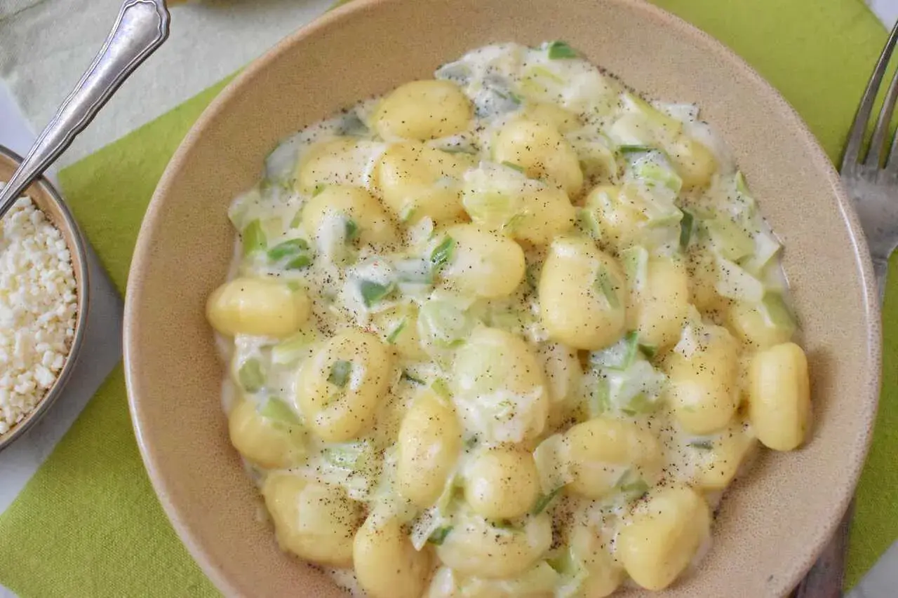 Puszyste gnocchi w kremowym sosie z gorgonzolą i porem, posypane świeżo mielonym pieprzem. Idealne danie dla miłośników wyrazistych smaków.