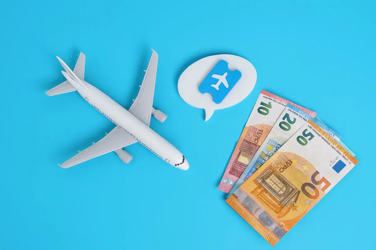Avión de juguete, billetes de euro y un ticket aéreo. Piensa en cuándo es mejor comprar vuelos para ahorrar.