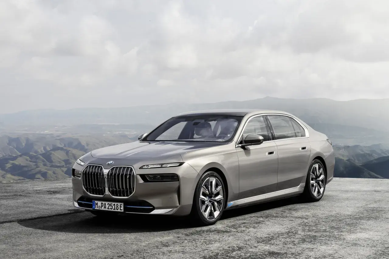 Elegancki, szary sedan BMW 7 2025 na tle górskiego krajobrazu.
