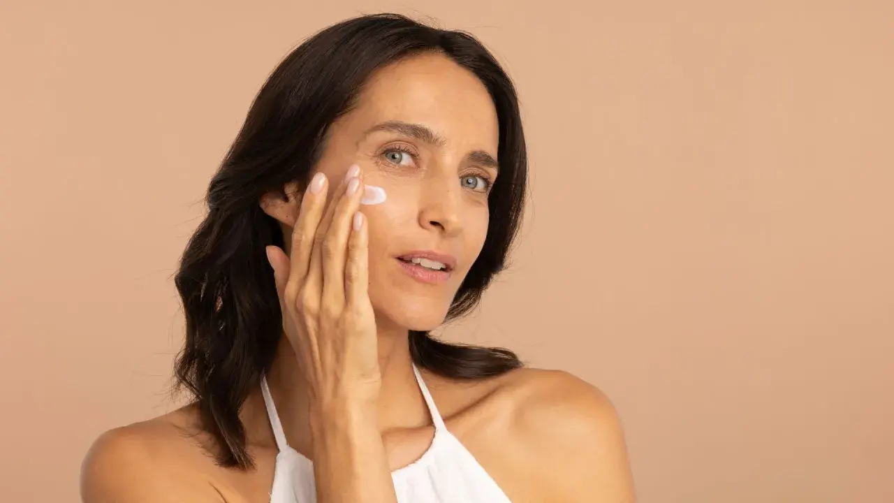 Une femme applique une crème hydratante pour lutter contre la peau sèche.