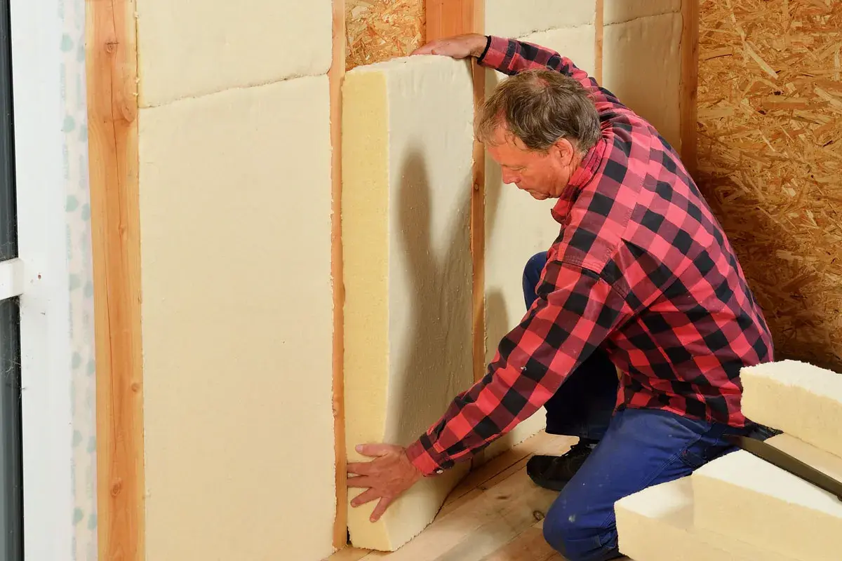 Man installerar hygroskopisk isolering i en väggkonstruktion.