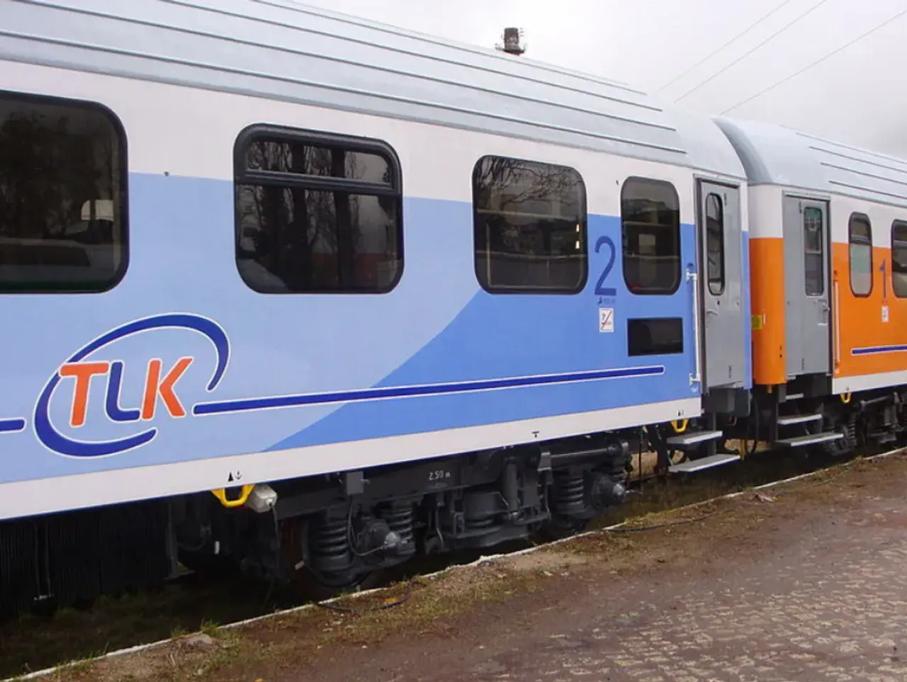 Wagon TLK z niebieskim pasem i logo. Czy w pociągach TLK są gniazdka? Warto sprawdzić, bo podróż z naładowanym telefonem jest przyjemniejsza.