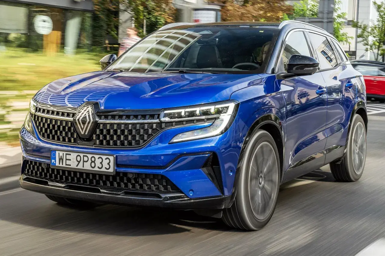 Błękitny Renault Austral pędzi po drodze, jego nowoczesny design i sportowy charakter przyciągają wzrok.