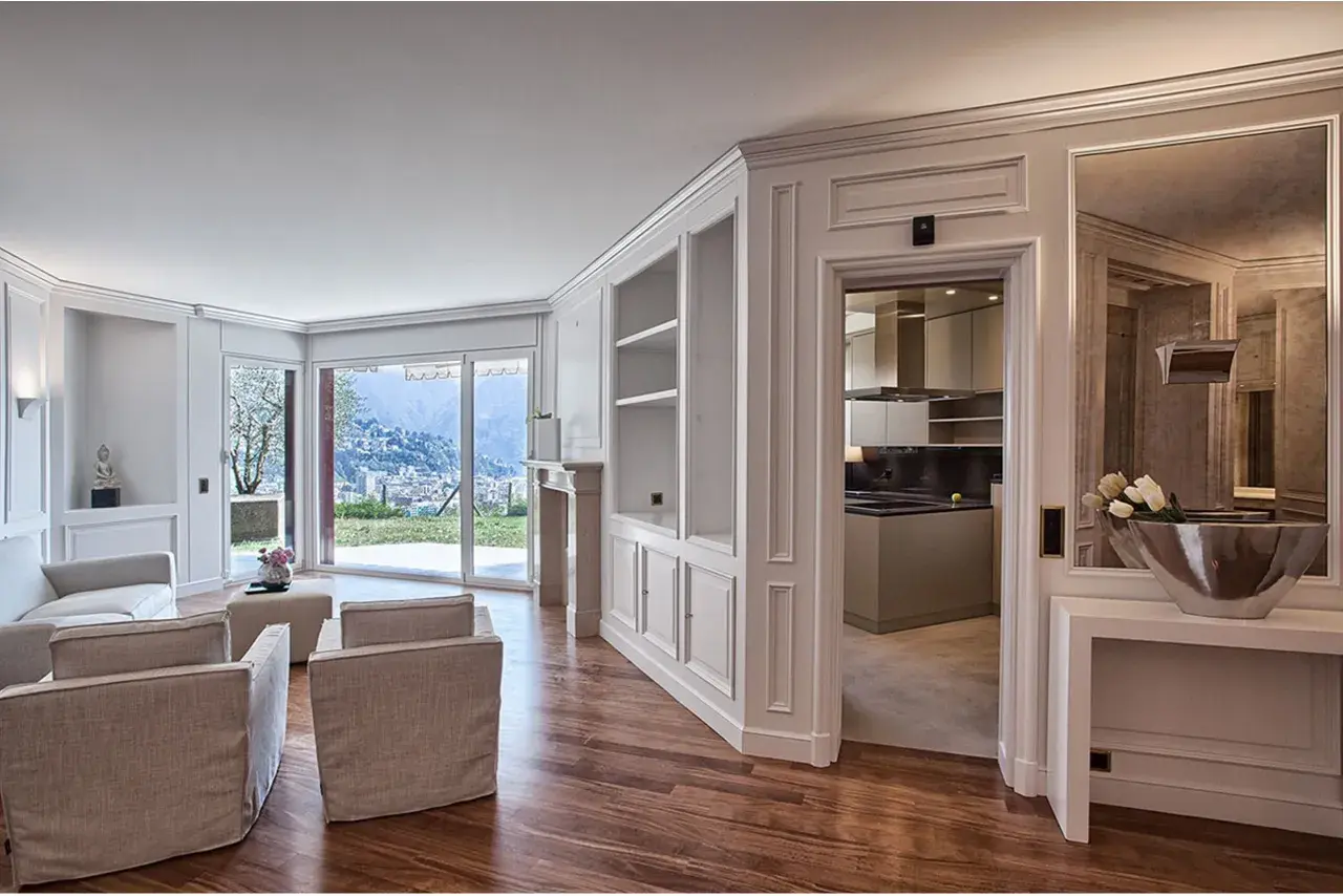 Soggiorno elegante con camino, divani, vista panoramica e cucina moderna. Le pareti in cartongesso effetto legno creano un'atmosfera calda e accogliente.