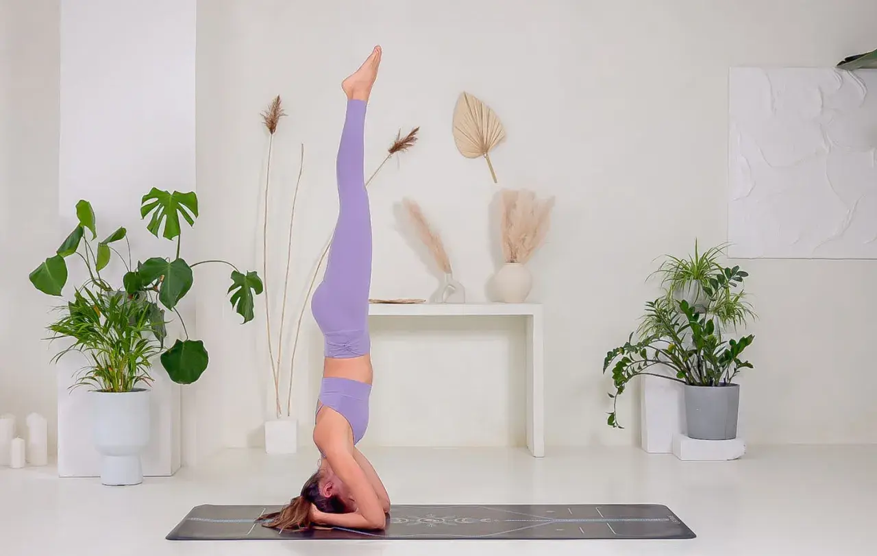 Donna in posa di Sirsasana, una delle inversioni yoga più conosciute.