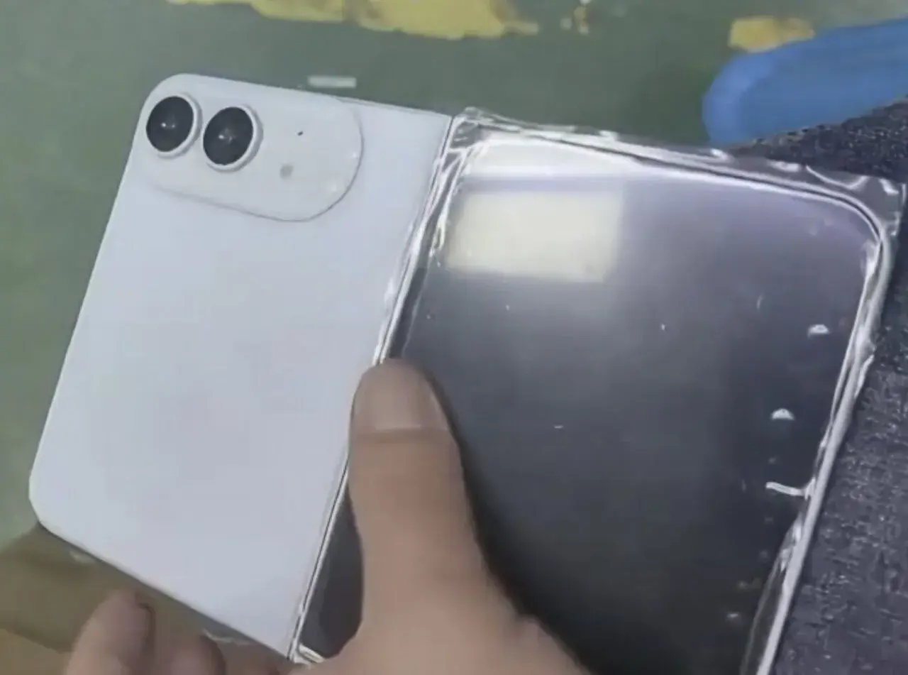 Biały telefon z dwoma aparatami, przypominający iPhone flip, jest rozkładany.
