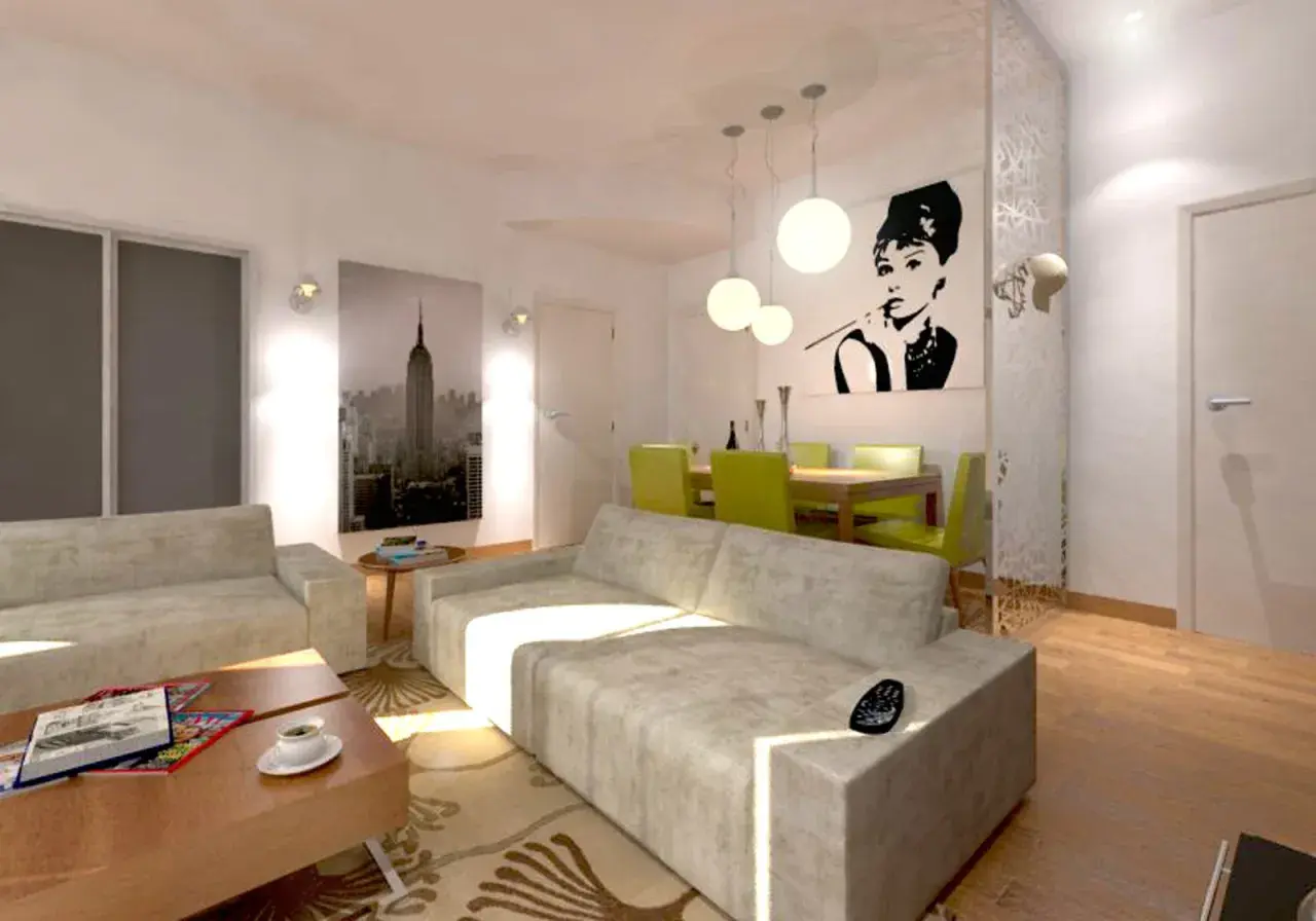 Un moderno soggiorno con un divano davanti alla porta finestra, un quadro di Audrey Hepburn e una vista di New York.