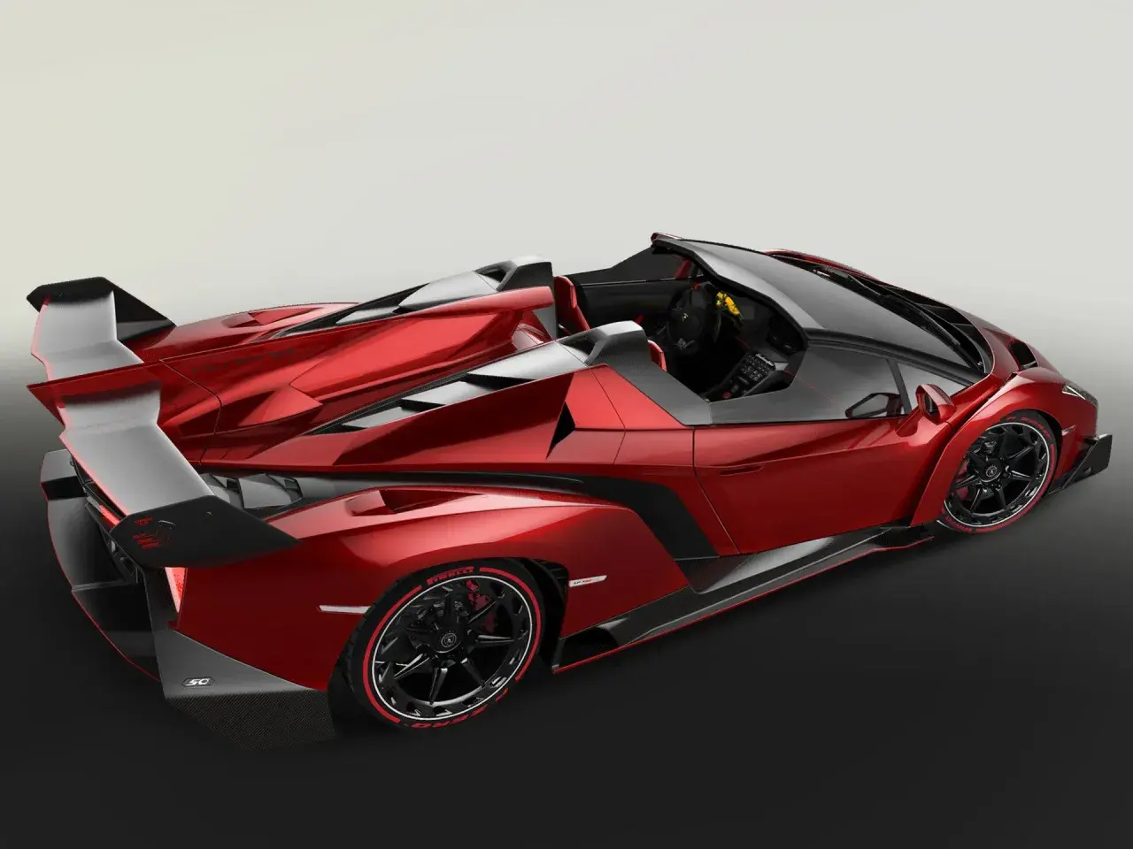 Czerwony, otwarty Lamborghini Veneno z czarnymi akcentami i masywnym spojlerem.