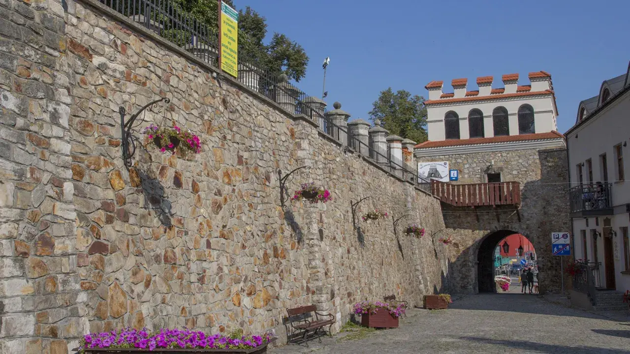 Kamienny mur i zabytkowa brama w Opatowie zapraszają do odkrywania urokliwych atrakcji.