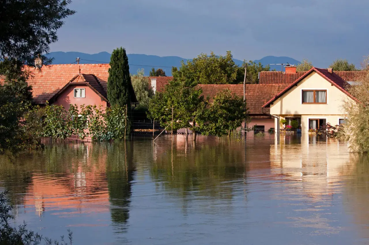Des maisons submergées par les eaux, reflétant la faible valeur d'une maison en zone inondable.