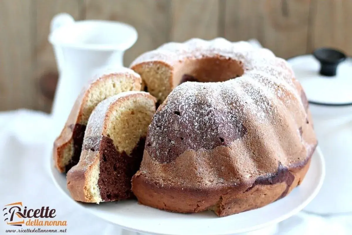 Un delizioso ciambellone bicolore, con cacao e vaniglia, spolverato di zucchero a velo, pronto per essere gustato.