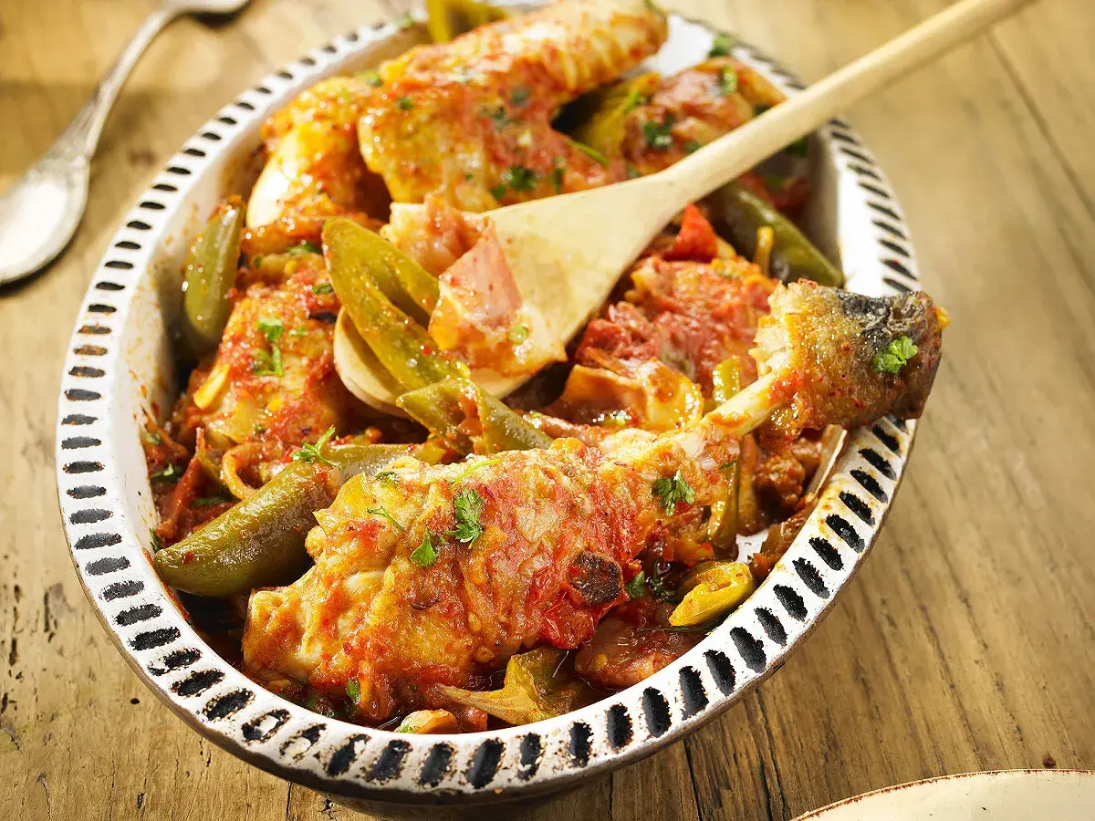 Un plat de poulet basquaise appétissant, préparé au Cookeo, garni de poivrons verts et d'une sauce tomate savoureuse.