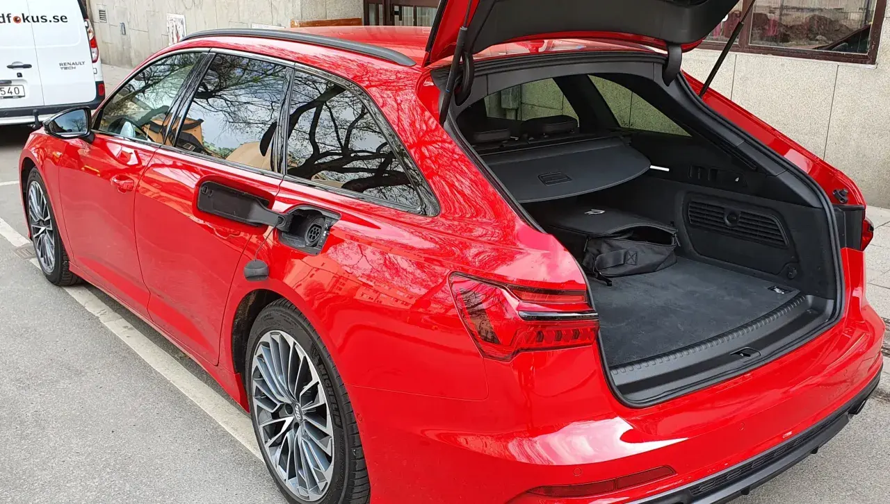 Röd Audi A6 Avant med öppet bagageutrymme. En svart väska ligger i det rymliga audi a6 bagageutrymmet.