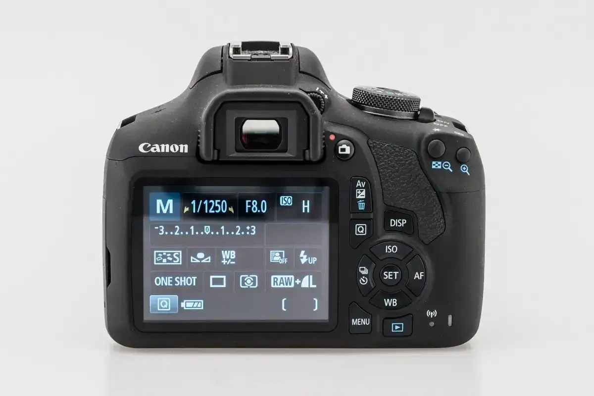 Tył aparatu Canon z widocznym ekranem LCD pokazującym ustawienia manualne (M), czas 1/1250s, przysłonę F8.0, ISO i inne parametry. Dowiedz się, jak dobrze ustawić aparat Canon.