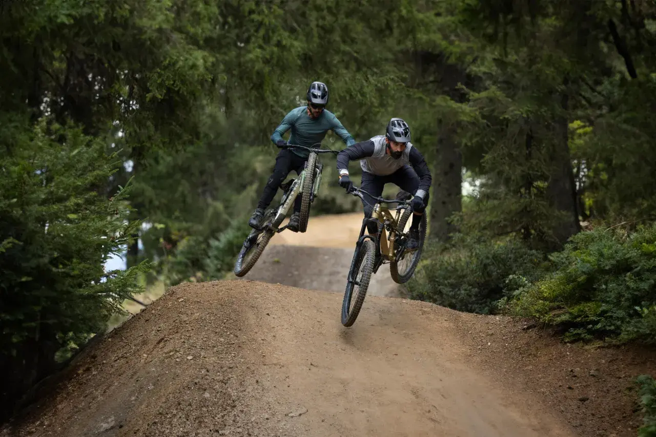 Dwóch rowerzystów w powietrzu na trasie zjazdowej. To właśnie **enduro co to** za sport, adrenalina i wolność!