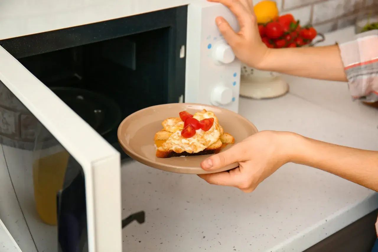 Piatto con toast, uova e pomodorini appena sfornati dal microonde.