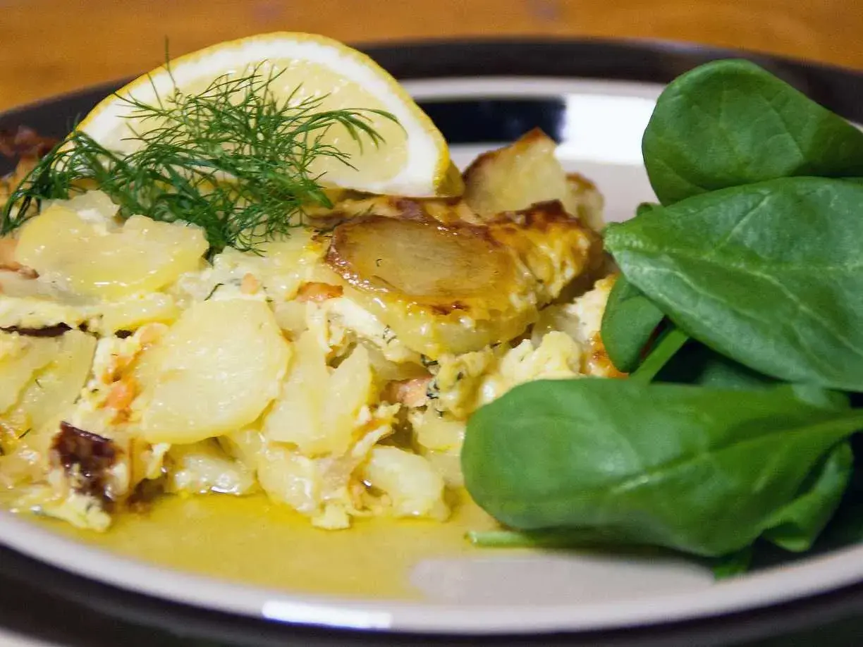 Enkel laxpudding med potatis, dill och citron. Serveras med färsk spenat.