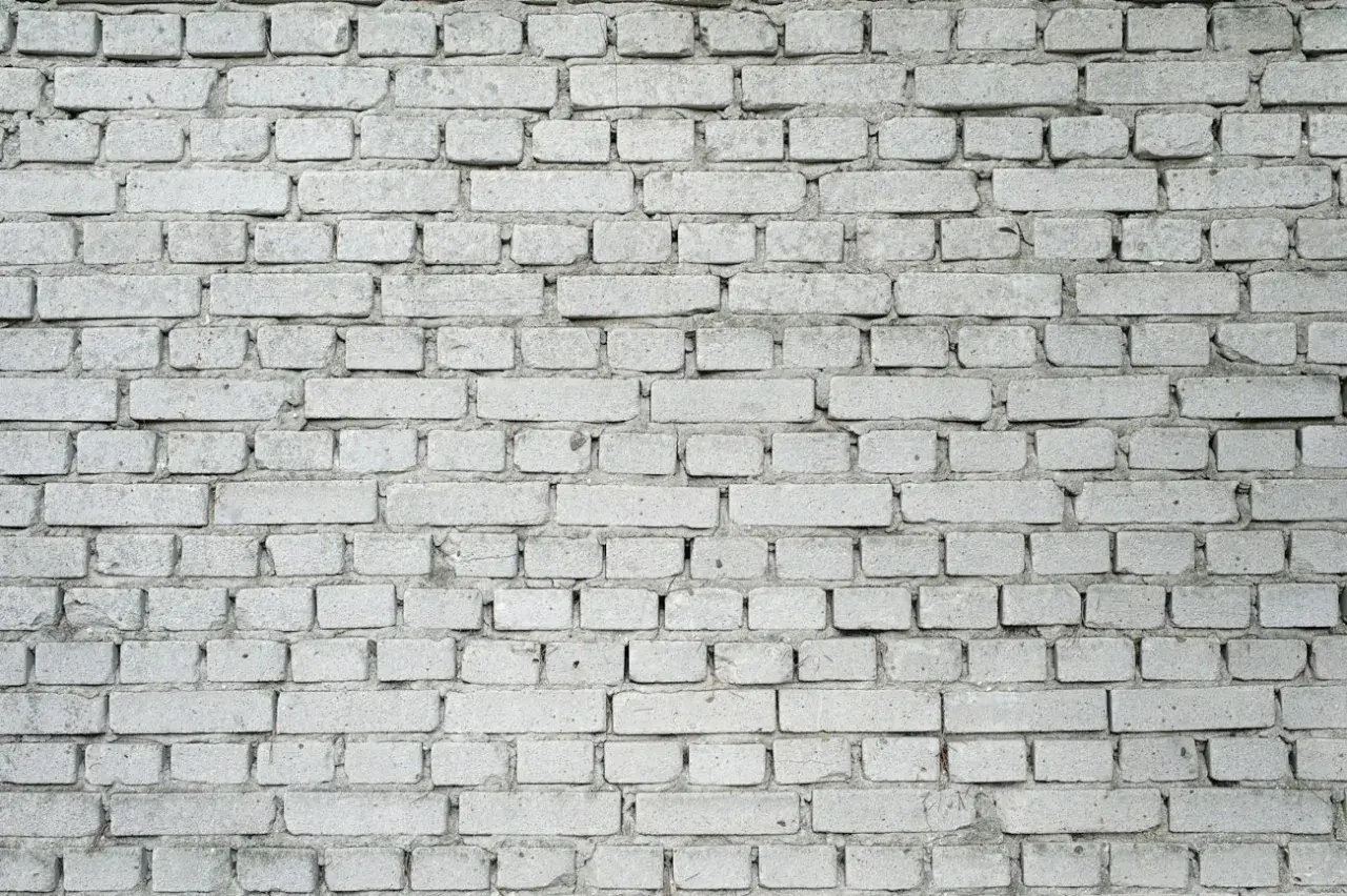 Szara ściana z cegieł, zastanawiasz się, ile waży jedna cegła?