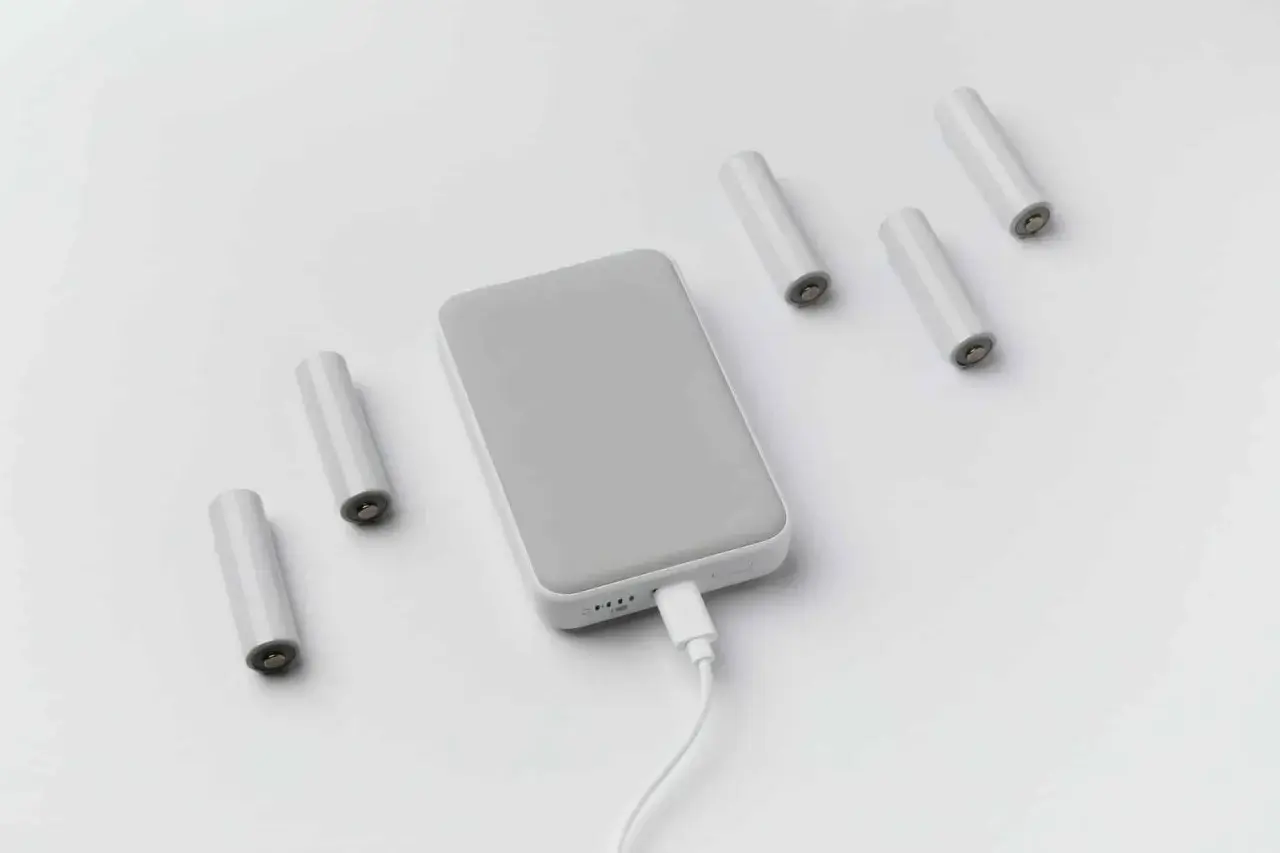 Szare baterie i powerbank podłączony kablem. Czy można mieć powerbank w bagażu podręcznym? Tak, zazwyczaj można.