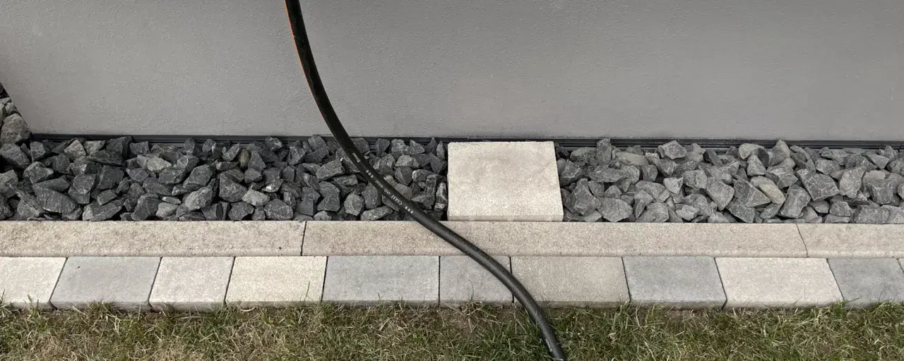 Moderner Spritzschutz am Haus: Kies und Steinplatten schützen die Fassade vor Nässe.