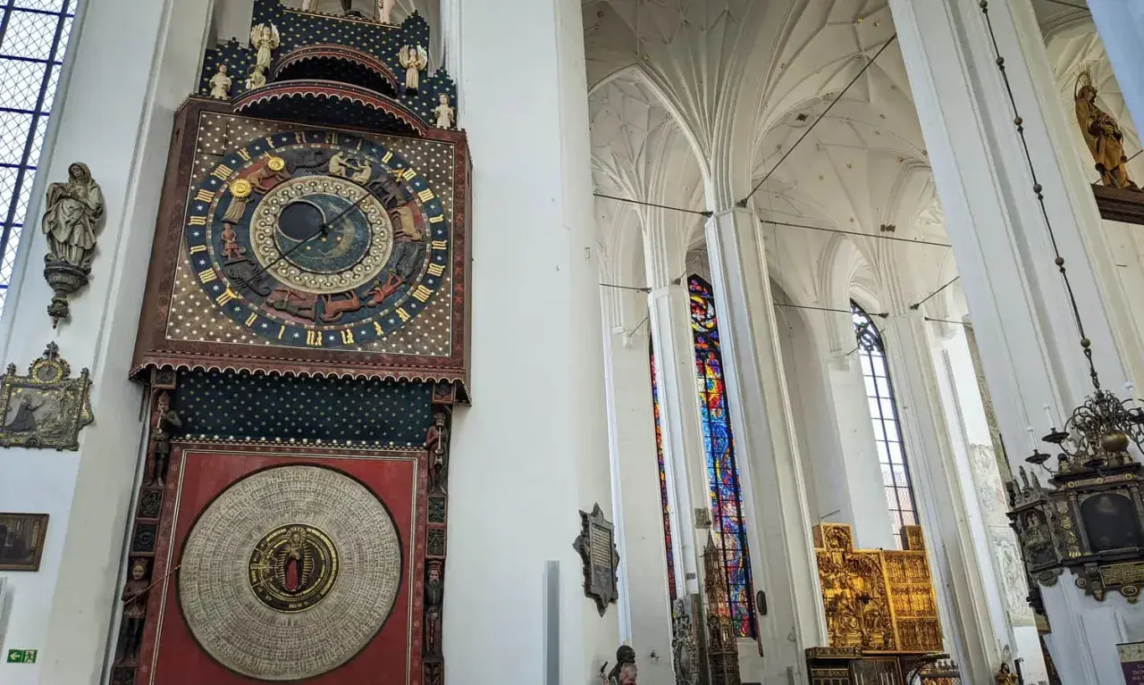 Wnętrze Bazyliki Mariackiej w Gdańsku. Imponujący zegar astronomiczny i witraże zachwycają podczas zwiedzania.