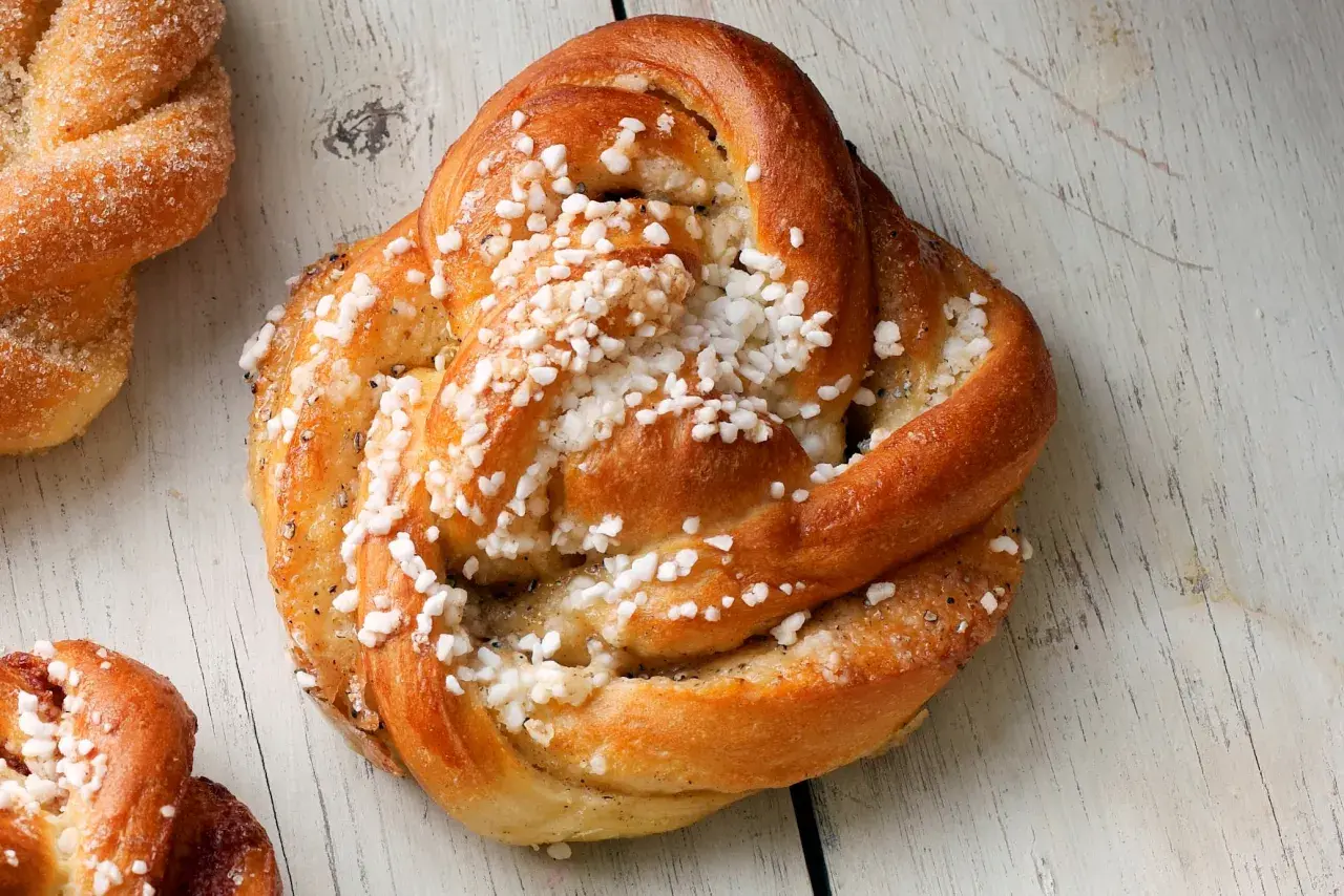 Gyllene kardemummabullar med pärlsocker, redo att bakas enligt ett enkelt kardemummabullar recept.