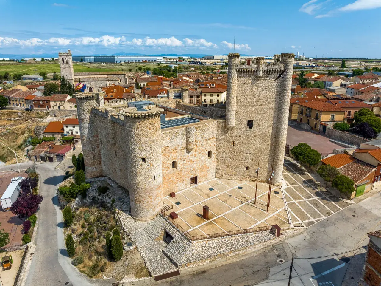 Castillo medieval en un pueblo bonito de Guadalajara, con tejados rojos y cielo azul.