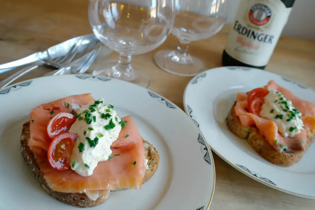 Två läckra gravad lax mackor med krämig topping och körsbärstomater. Perfekt för en mysig fika.