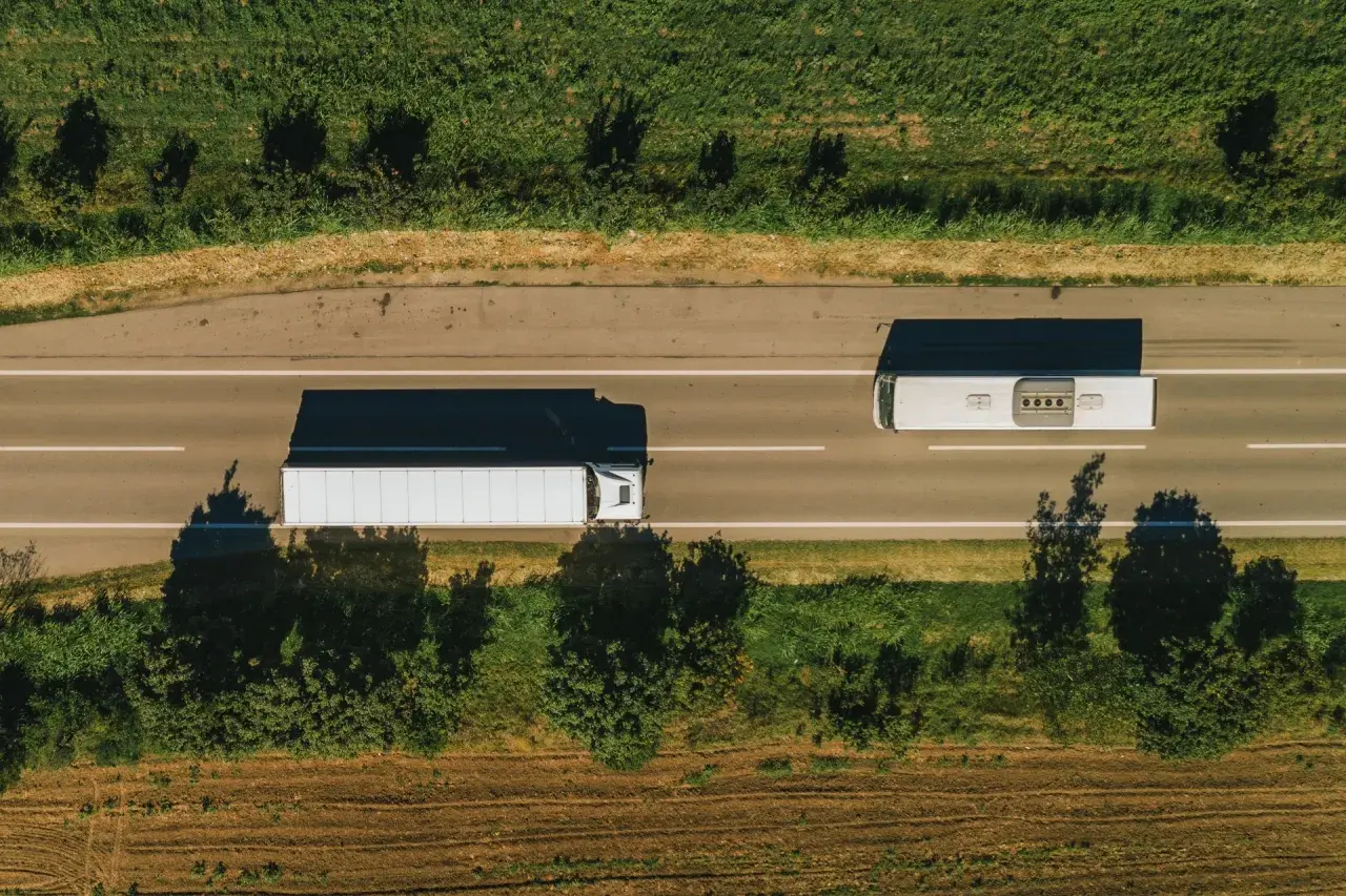 Ciężarówka i autobus jadą drogą. Zastanawiasz się, ile kosztuje tona klińca drogowego?