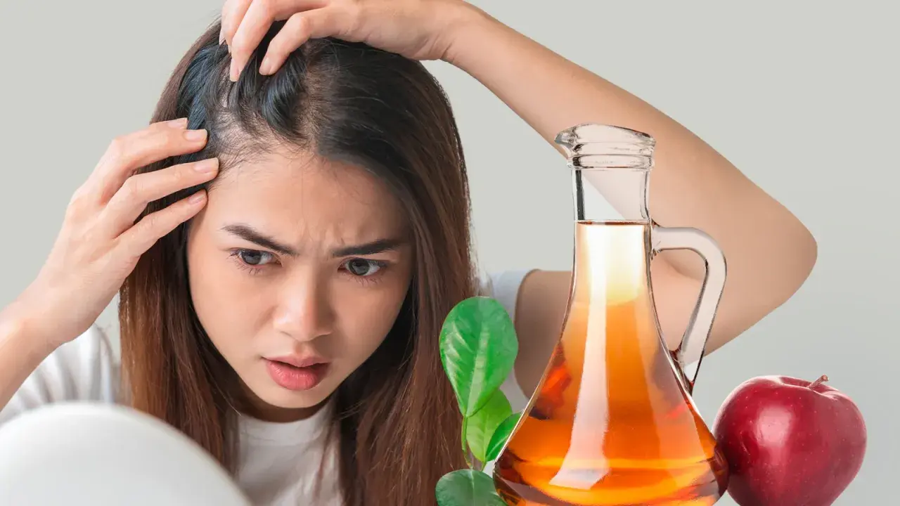Mujer preocupada revisa su cabello. A su lado, una botella de vinagre de manzana para el pelo y una manzana roja.