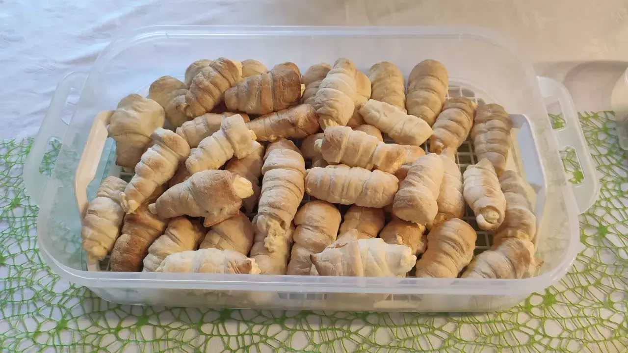 Duża porcja rurek z kremem w przezroczystym pojemniku.