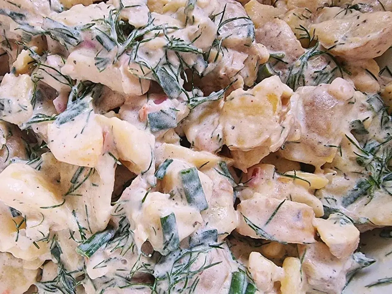Cremiger Kartoffelsalat mit Schmand, verfeinert mit frischem Dill und Schnittlauch. Ein Klassiker, der immer schmeckt.