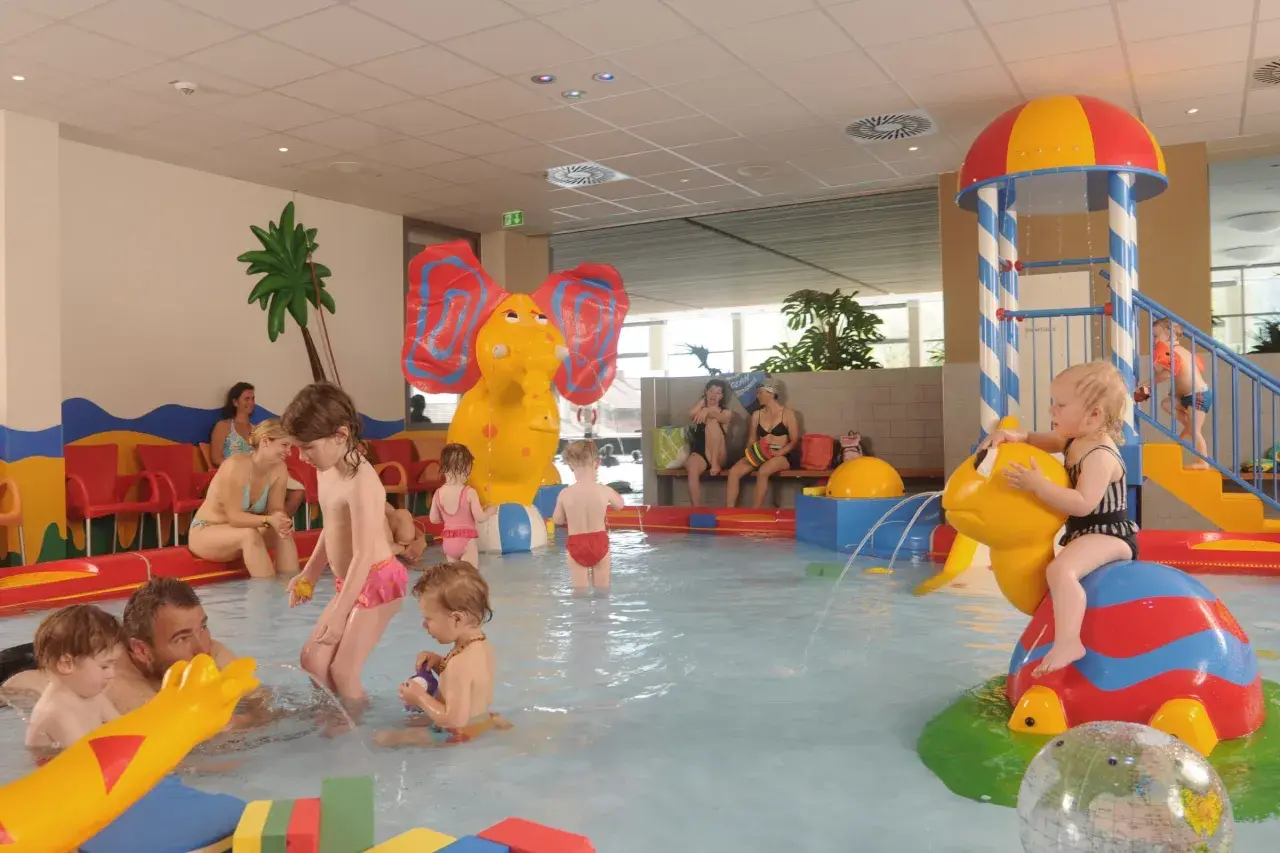 Fröhliche schwimmbad kinder planschen im Wasser, spielen mit bunten Figuren und rutschen. Ein Elefant und eine Schildkröte sorgen für Spaß.