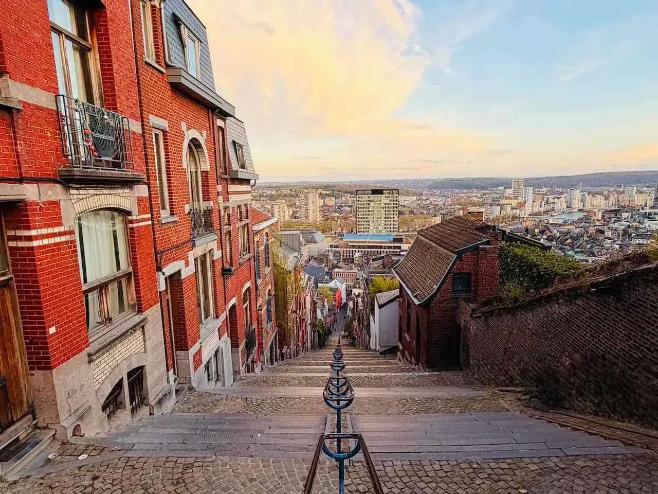 Treppen hinunter in eine Stadt in Belgien. Erkunden Sie die charmanten Gassen und genießen Sie die Aussicht – so kann man in Belgien machen!