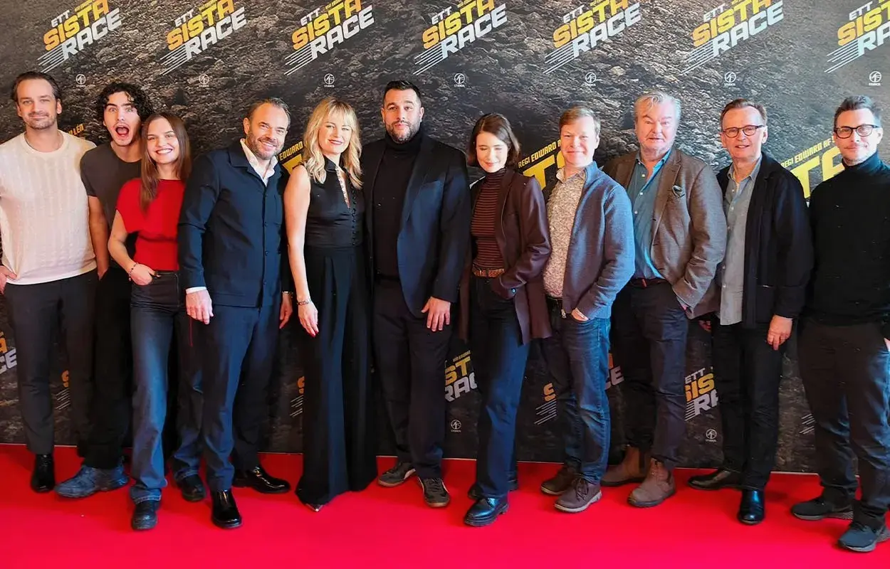 Rollistan i ett sista race samlad på röda mattan. Skådespelare och regissör poserar framför en bakgrund med filmens logotyp.