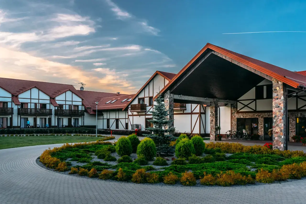Hotel Mikołajki Leisure & Spa: piękne budynki z czerwonymi dachami, zadbany ogród i podjazd. Wiele pozytywnych hotel mikołajki leisure & spa opinie.