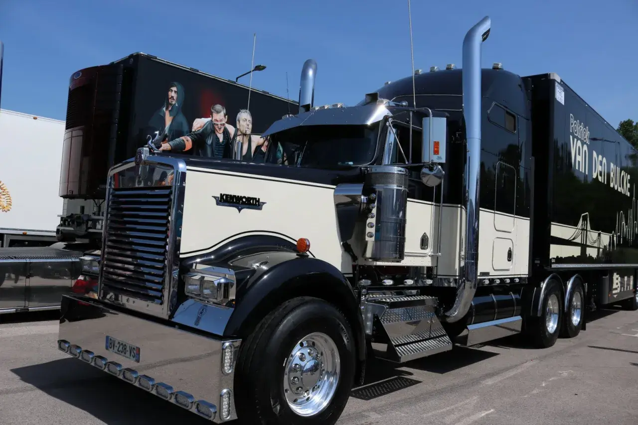 Beau camion américain Kenworth noir et crème, avec une peinture personnalisée sur la remorque.