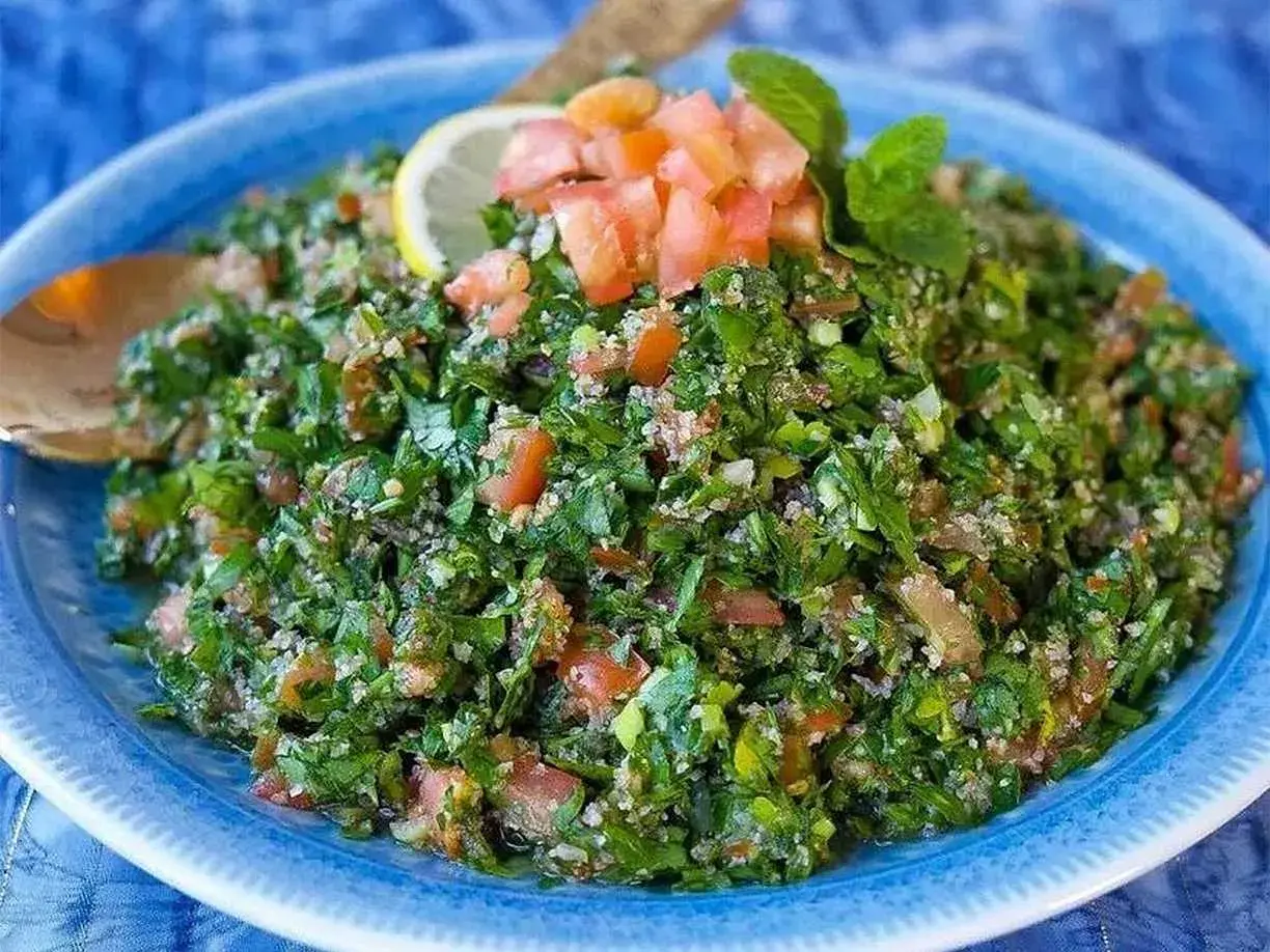 Zeinas tabbouleh, en fräsch persiljesallad med tomat och bulgur, toppad med citron och mynta.