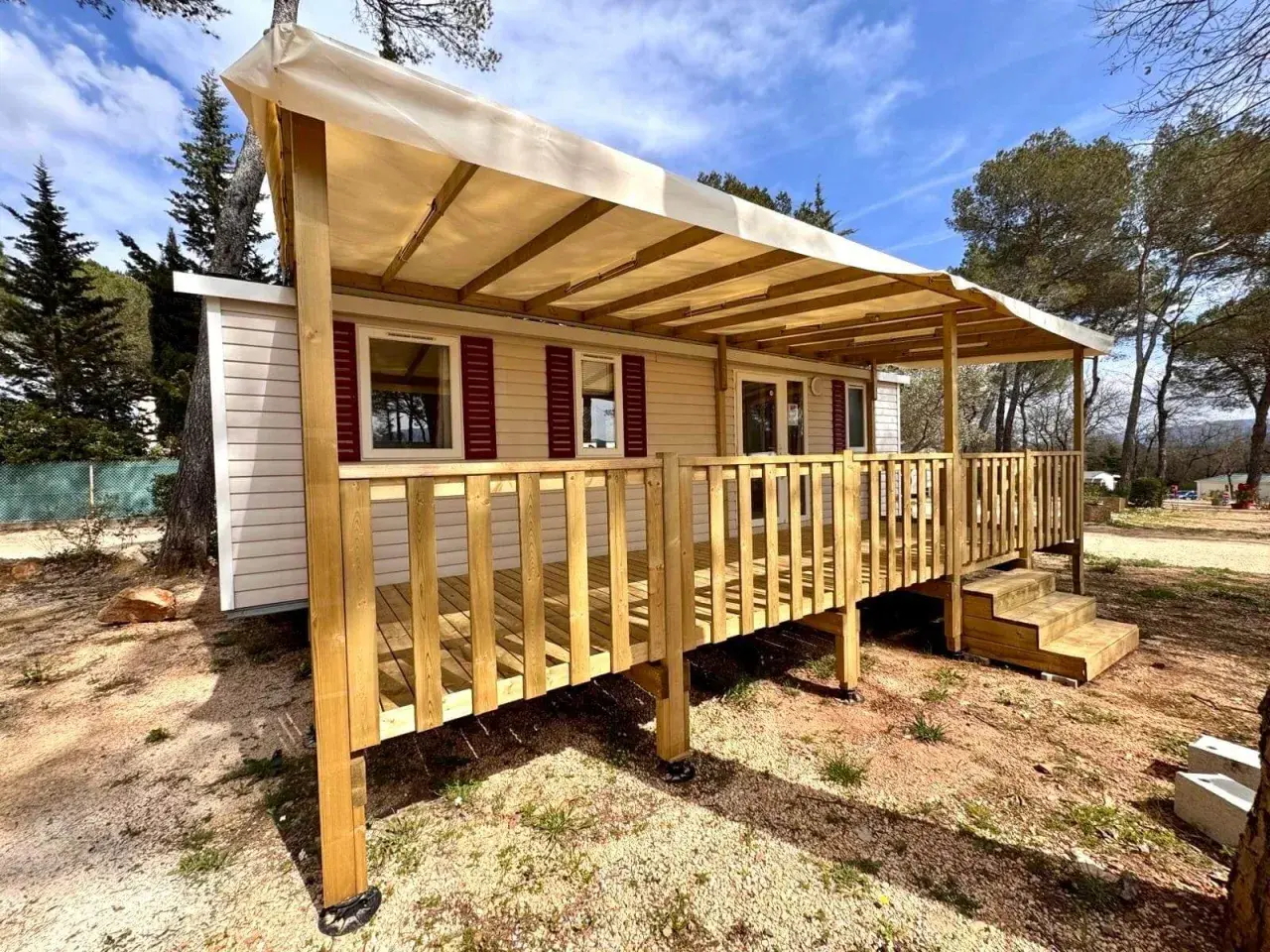 Mobil-home avec terrasse en bois sous un auvent, dans un cadre verdoyant. Une image qui pourrait illustrer la jurisprudence mobil-home.